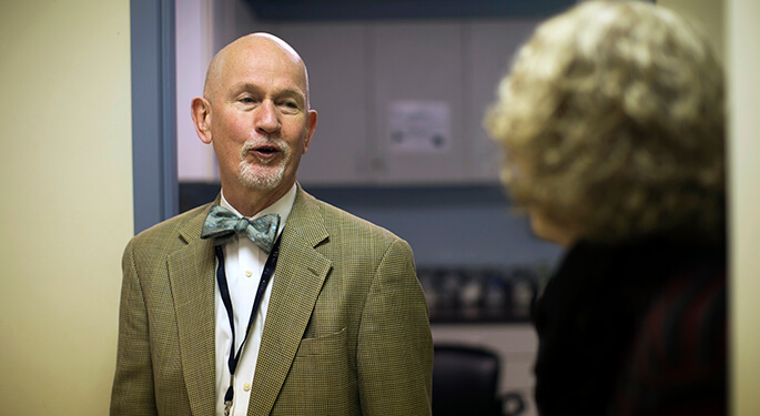 Image of a male and female talking in a patient care office